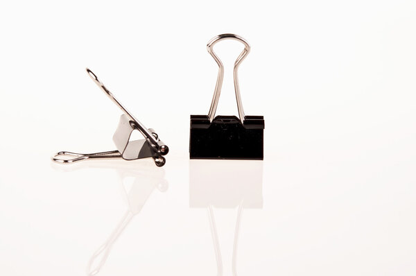 две черные скрепки для бумаги на белом фоне
