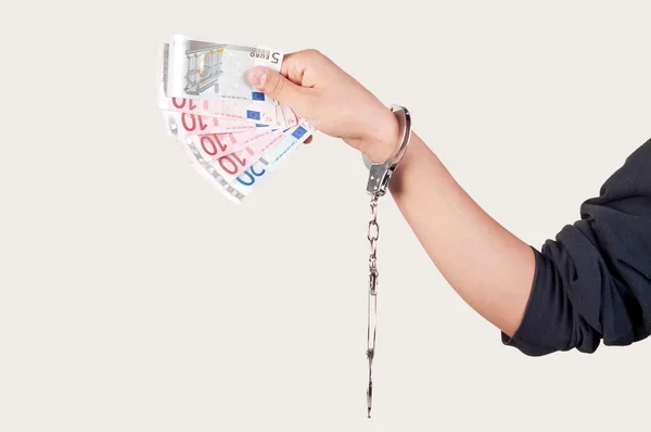 Hand with handcuffs holding money — Stock Photo, Image
