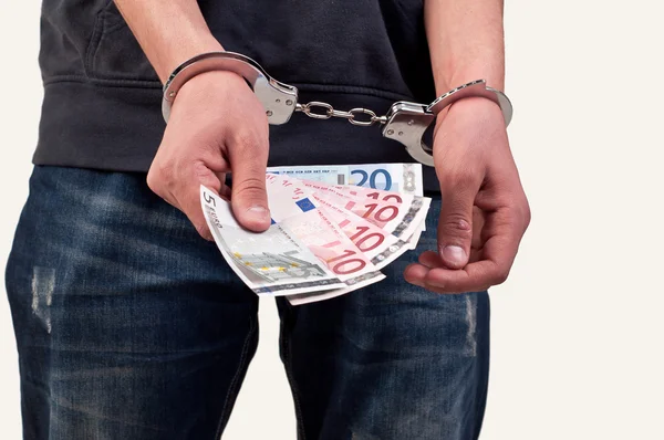 Man in handcuffs is holding money over white background — Stock Photo, Image