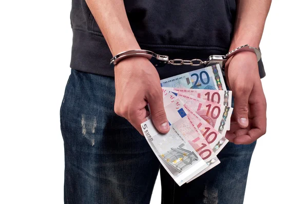 Людина в наручниках тримає гроші на білому тлі — стокове фото
