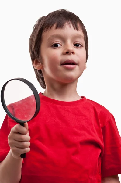 Liten pojke leker med förstoringsglas på vit bakgrund — Stockfoto