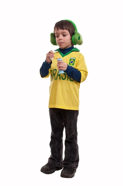 Kleine jongen een paar pluizige oorwarmers dragen in de vorm van spelen met zeepbellen kikker — Stockfoto