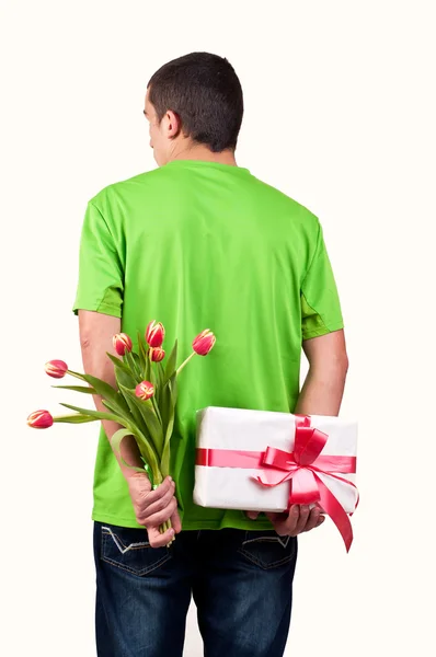 Mann versteckt Blumen und Geschenkbox hinter seinem Rücken — Stockfoto