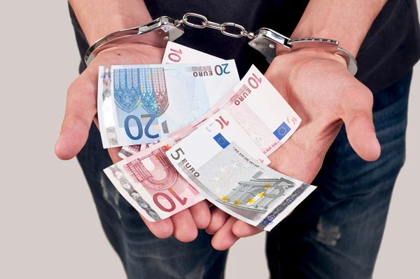 Людина в наручниках тримає гроші — стокове фото