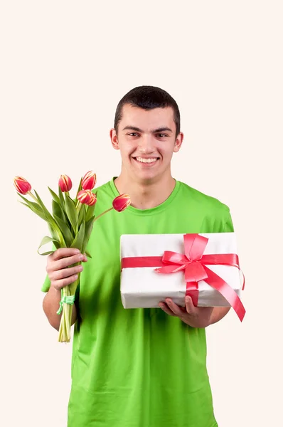 Junger Mann mit einem Strauß Tulpen und Geschenkkarton — Stockfoto