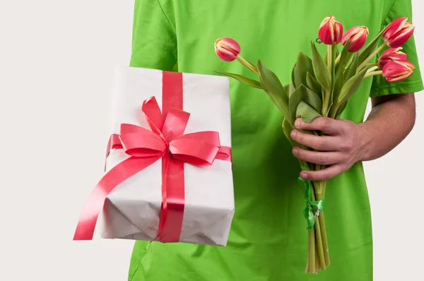 Caixa de presente e tulipas frescas na mão do homem — Fotografia de Stock