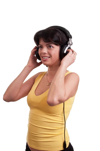 Hermosa mujer morena es escuchar la música en los auriculares — Foto de Stock