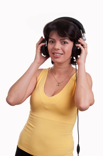 Hermosa mujer morena es escuchar la música en los auriculares —  Fotos de Stock