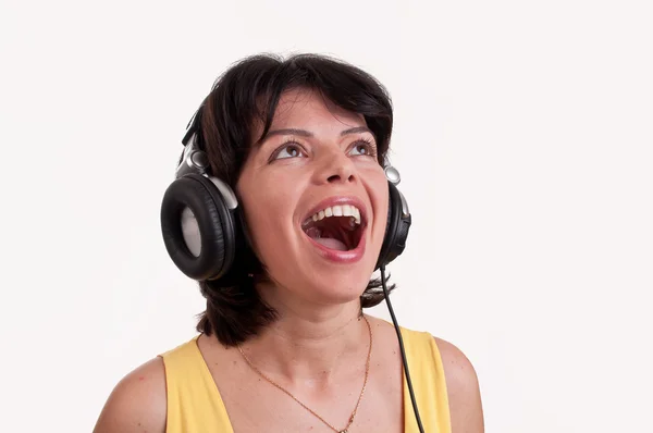 Primer plano de una mujer escuchando música en auriculares disfrutando de un baile sobre fondo blanco —  Fotos de Stock