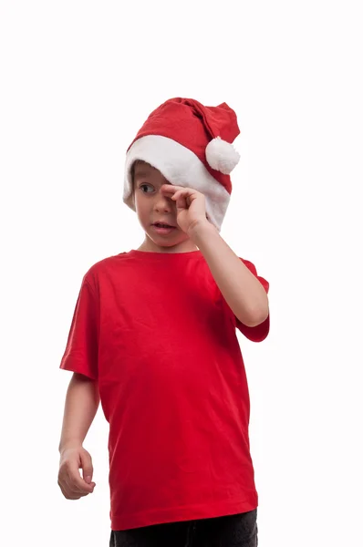Söta, ledsen pojke bär en santa hatt och röd tröja — Stockfoto