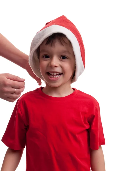 Mutlu çocuk annesi tarafından santa şapka koymak için yardımcı oldu — Stok fotoğraf