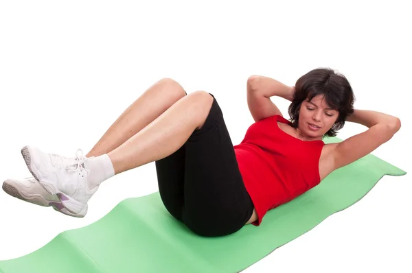 Jovem fazendo exercício para abdominais isolados em fundo branco — Fotografia de Stock