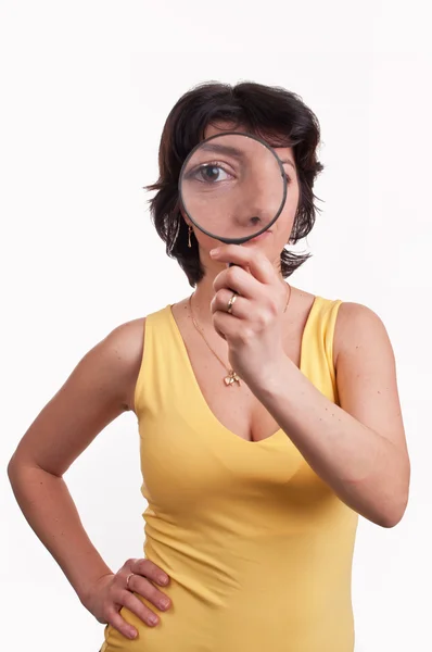 Young woman with magnifying glass at her eye — Stock Photo, Image