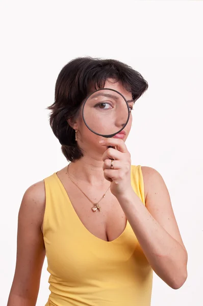 Young woman with magnifying glass at her eye — Stock Photo, Image