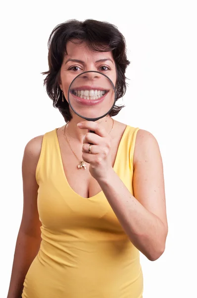 Young woman with magnifying glass at her mouth - Showing teeth — Stock Photo, Image