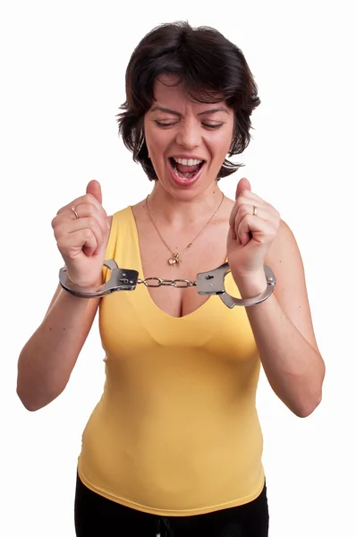 Angry young woman in handcuffs trying to free herself — Stock Photo, Image