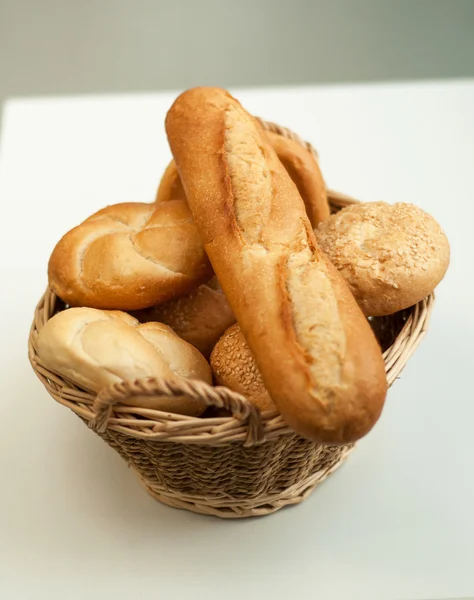 Bread loaves and baguettes in a wicker basket — Stock Photo, Image