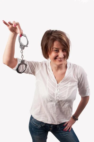 Close up of a beautiful woman smiling and showing handcuffs — Stock Photo, Image