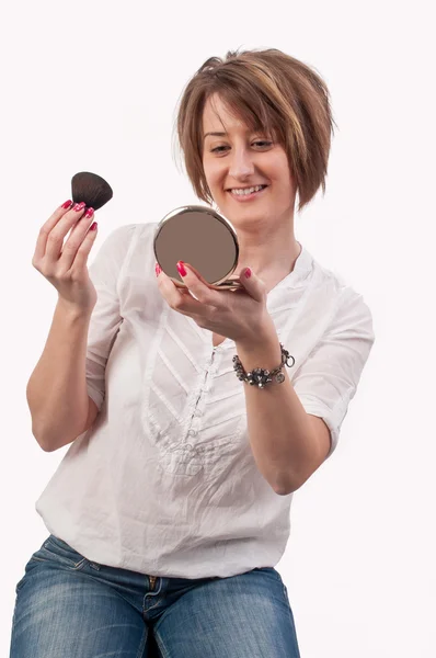 Atractiva joven mujer sosteniendo un cepillo y un espejo en sus manos , — Foto de Stock