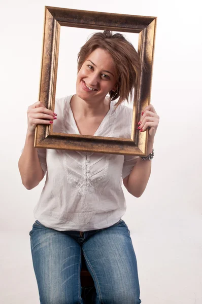 Grappige mooie vrouw houden rond haar gezicht een frame — Stockfoto