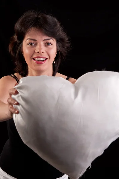 En vacker ung kvinna med ett vitt hjärta i hand — Stockfoto