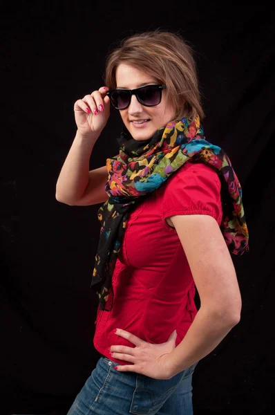 Модная женщина в солнцезащитных очках и шарфе, позирующая на черной заднице — стоковое фото