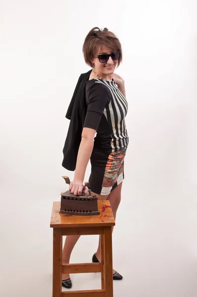 Shot of a young woman with sunglasses trying to ironing her clot — Stock Photo, Image