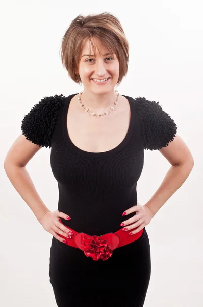 Young lady in black dress and red belt posing with her hands on — Stock Photo, Image