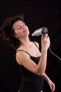 güzel bir kadın üzerinde siyah backgr saç kurutma makinesi ile saç kurutma