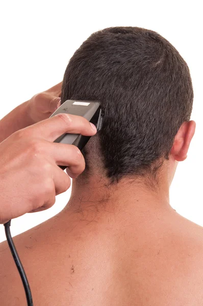 Homem com um corte de cabelo com um cortador de cabelo sobre um backgroun branco — Fotografia de Stock