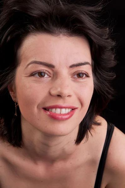 Close up of cheerful beautiful young woman posing on black backg — Stock Photo, Image