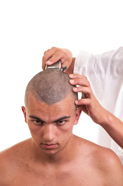 Barber cutting hair to a young man with clipper on white — Stock Photo, Image