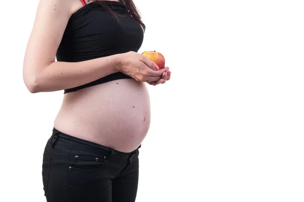 Mujer embarazada sosteniendo una manzana en sus manos sobre fondo blanco — Foto de Stock