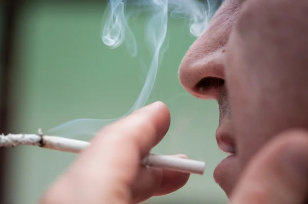 Fechar de um homem fumando cigarro — Fotografia de Stock