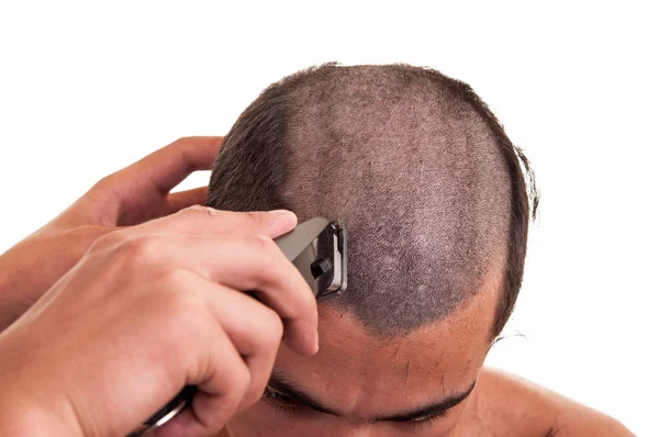 Homem com um corte de cabelo com um cortador de cabelo sobre um backgroun branco — Fotografia de Stock