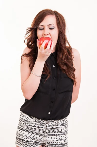 Giovane bella donna mordere una mela rossa su sfondo bianco — Foto Stock