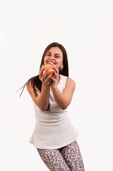 Young woman smiling and catching an grapefruit — Stock Photo, Image