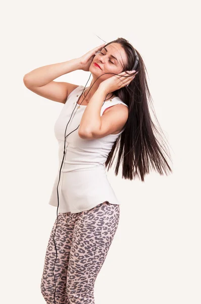 Beautiful young woman listening to music on headphones enjoying — Stock Photo, Image