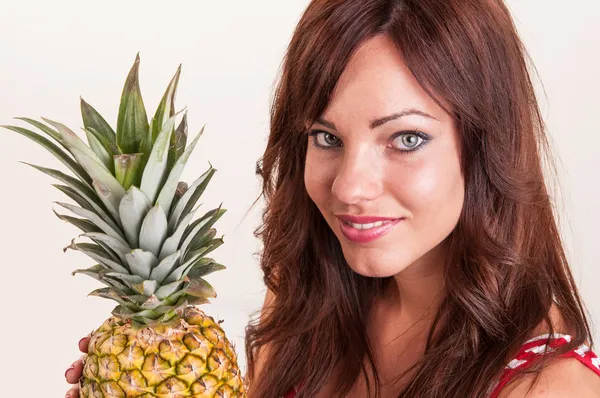 Porträtt av ung vacker kvinna visar ananas — Stockfoto
