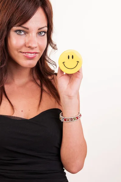 Beautiful young woman holding object with happy smiley — Stockfoto