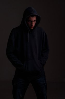 Genç hoodie ile bakmak karşı kirli koyu gri bir tarafta