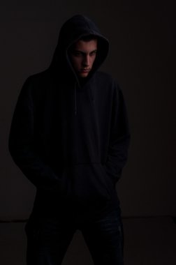 kirli bir siyah duvara bir tarafta genç hoodie ile bakmak