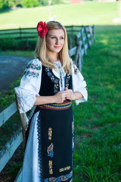 Bela mulher com flor vermelha em seu cabelo posando em romeno t — Fotografia de Stock