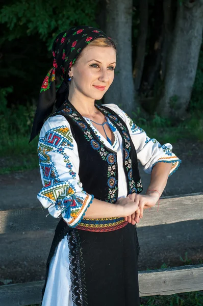 Porträt einer jungen schönen Frau, die draußen in rumänischer Tracht posiert — Stockfoto