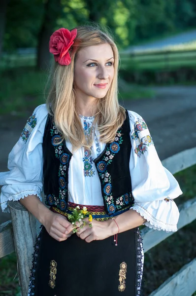 Beautiful singer with flowers posing in traditional costume, rom — Stock Photo, Image