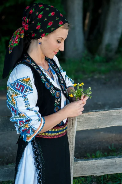 Bella cantante con fiori in mano posa in campagna — Foto Stock