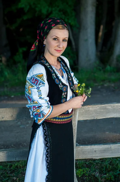 Güzel şarkıcı kırsal poz onun ellerinde çiçeklerle — Stok fotoğraf