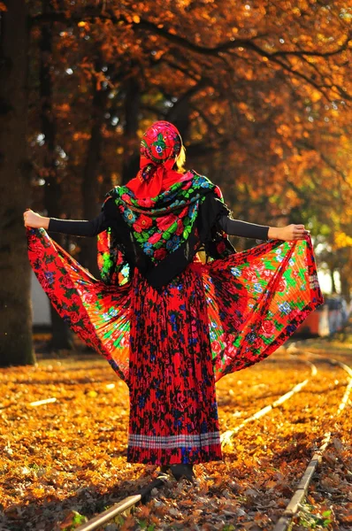 Romantic young gypsy woman pulls up dress and walks on the railr — Stock Photo, Image