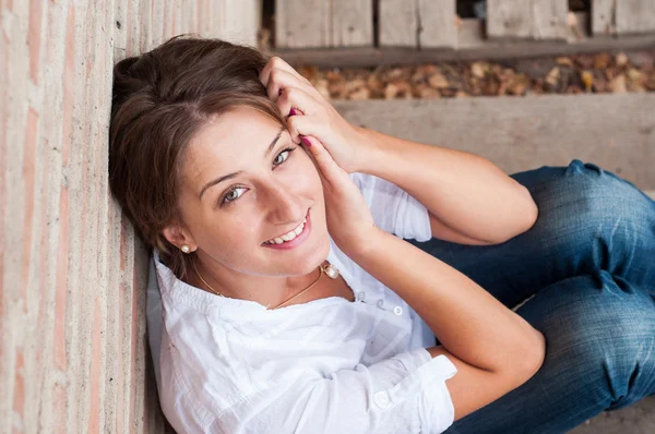 Schöne junge Frau posiert in der Nähe eines Zauns in der Natur — Stockfoto