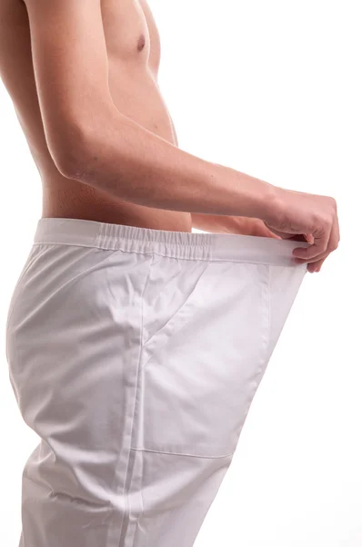 Close up of young man showing how much weight he lost — Stock Photo, Image